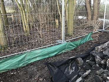 Amphibienzäune, Zaun mit grüner Barriere unten. Im Hintergrund Gehölz Foto: ASV