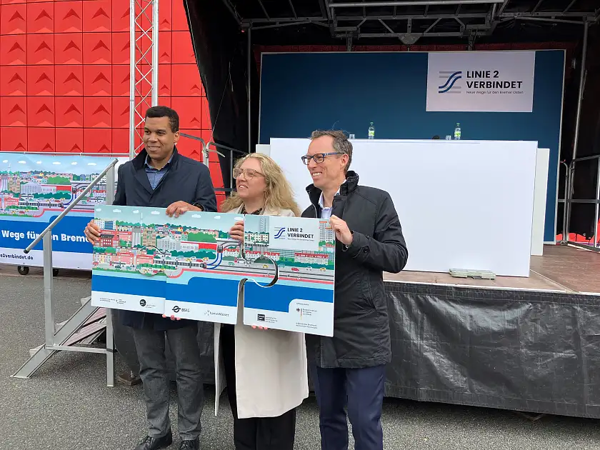 Rick Graue, Özlem Ünsal und Thorsten Harder halten gemeinsam ein Puzzle mit Motiven von der Projektwebseite.