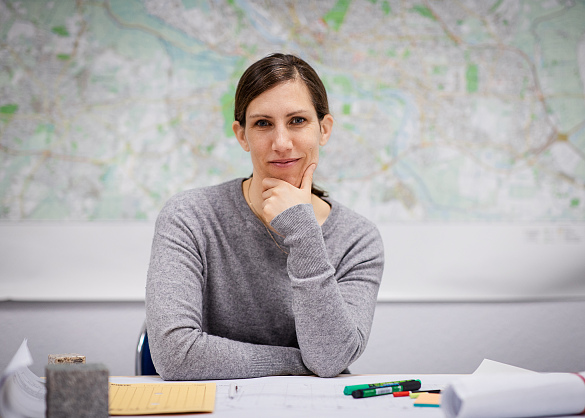 Frau Hartwig sitzt an einem Tisch in ihrem Büro