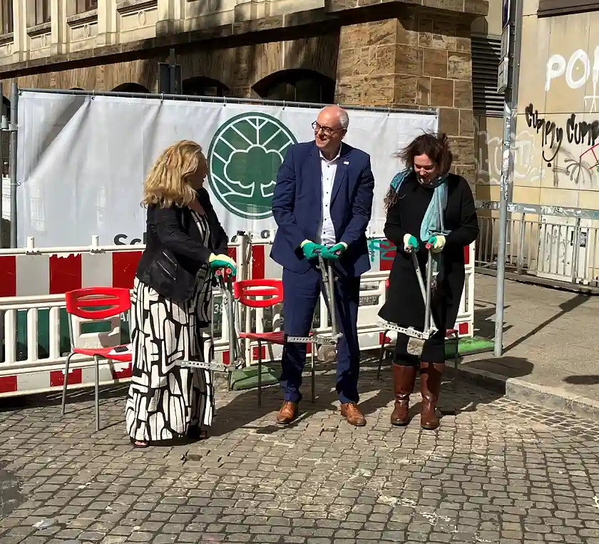 Von links nach rechts: Senatorin Ünsal, Bürgermeister Bovenschulte und Senatorin Moosdorf nehmen Steine aus dem Pflaster auf. 
˜ Bildnachweis: Foto: ASV