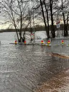 Überflutete Borgfelder Landstraße mit Absperrgittern und Bäumen, die von Wasser umspült werden.  Dezember 2023, Bild: ASV