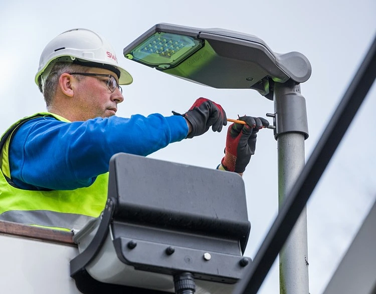 Ein Mitarbeiter von swb Beleuchtung nimmt den ersten Leuchtenaustausch im Rahmen des gef&ouml;rderten Projekts vor
