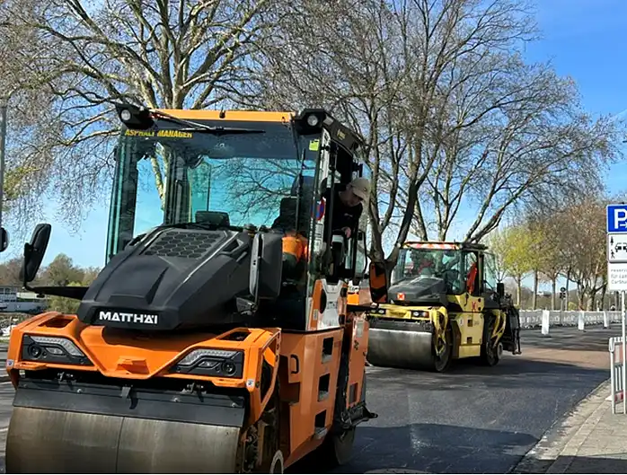 Hei&szlig;er Asphalt wird auf einem Teilst&uuml;ck des Osterdeichs aufgebracht.